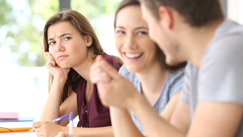 楽しそうに話す男女を見ている女性