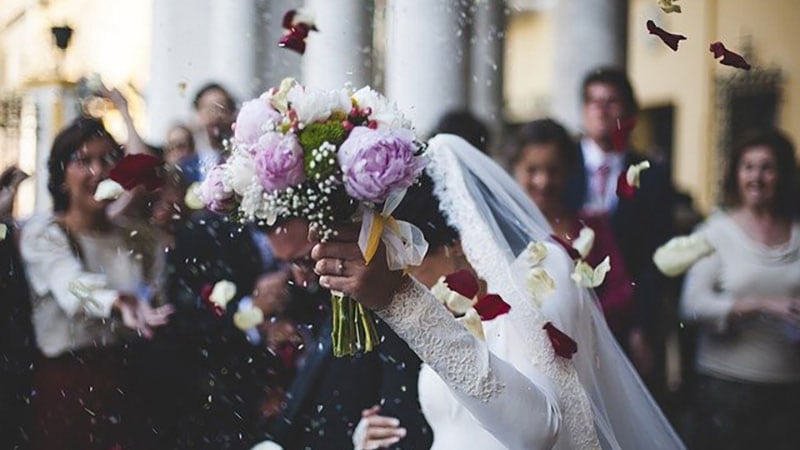 周囲に祝福されながら結婚する花嫁と花婿