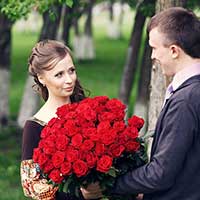花束を持ってプロポーズする男性